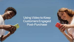 Two smiling young people looking at their phones against a blue sky, with the title "Using Video to Keep Customers Engaged Post-Purchase"