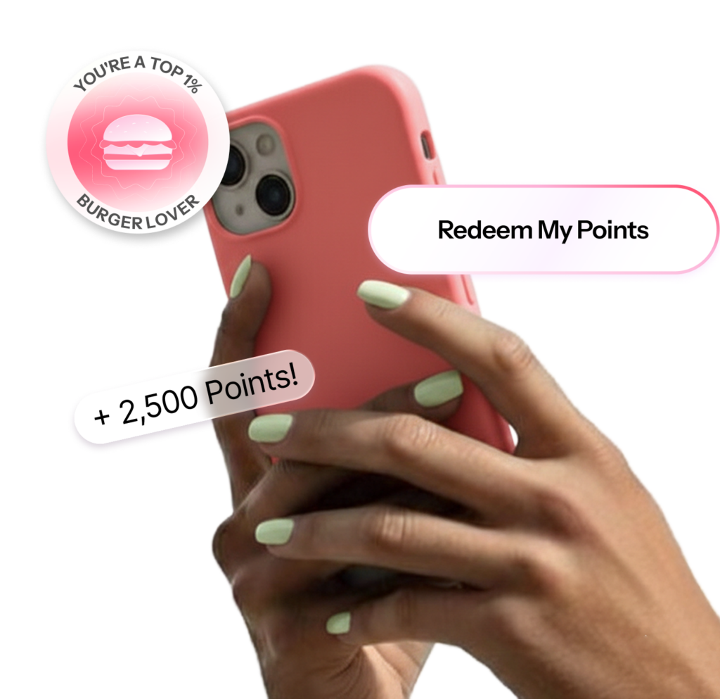 A hand holds a pink smartphone displaying a personalized video frame with a Redeem My Points button and a plus 2,500 Points reward callout.